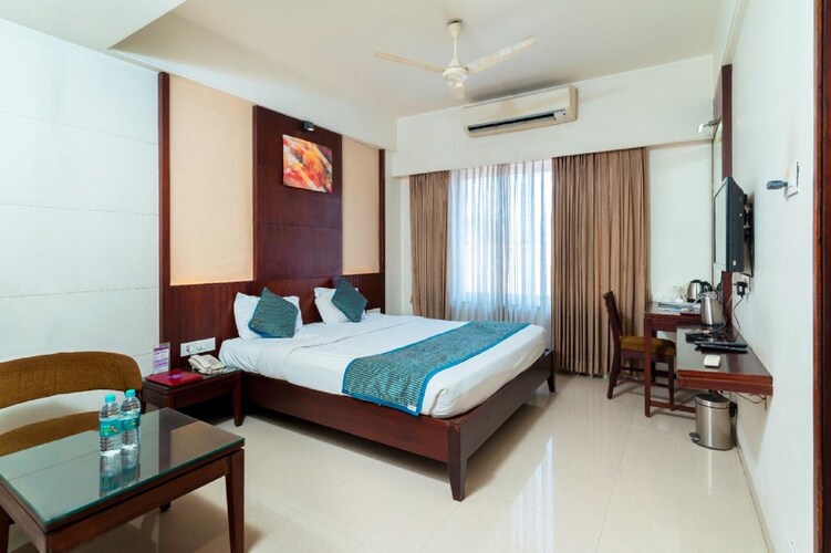 Deluxe Room at Hotel Chaitali with a made bed and seating